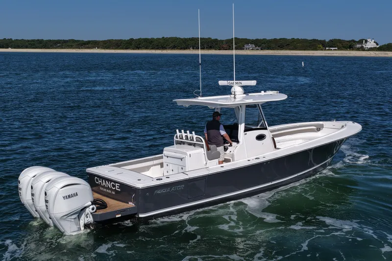 Shark Gray Yacht Photos Pics 2024 Regulator 34 boat cruising on open water with triple Yamaha engines.