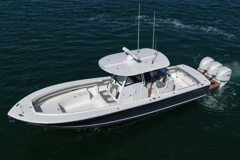 Shark Gray Yacht Photos Pics 2024 Regulator 34 boat cruising on open water, featuring triple outboard engines.