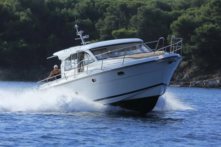  Yacht Photos Pics 2021 Nimbus 405 Coupé #88 cruising on water with forested background.