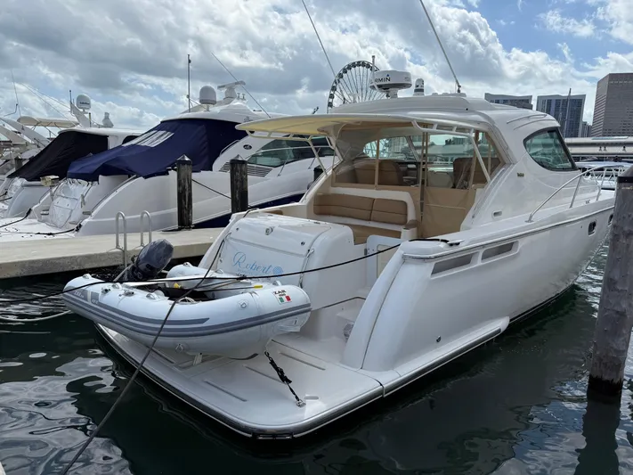  Yacht Photos Pics 2014 Tiara Yachts 4500 Sovran docked with inflatable boat, city skyline in background.