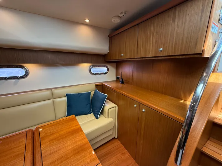  Yacht Photos Pics 2014 Tiara Yachts 4500 Sovran interior with wood cabinetry and beige seating.