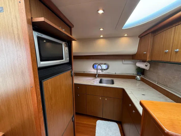  Yacht Photos Pics 2014 Tiara Yachts 4500 Sovran kitchen with wood cabinetry, sink, and microwave.