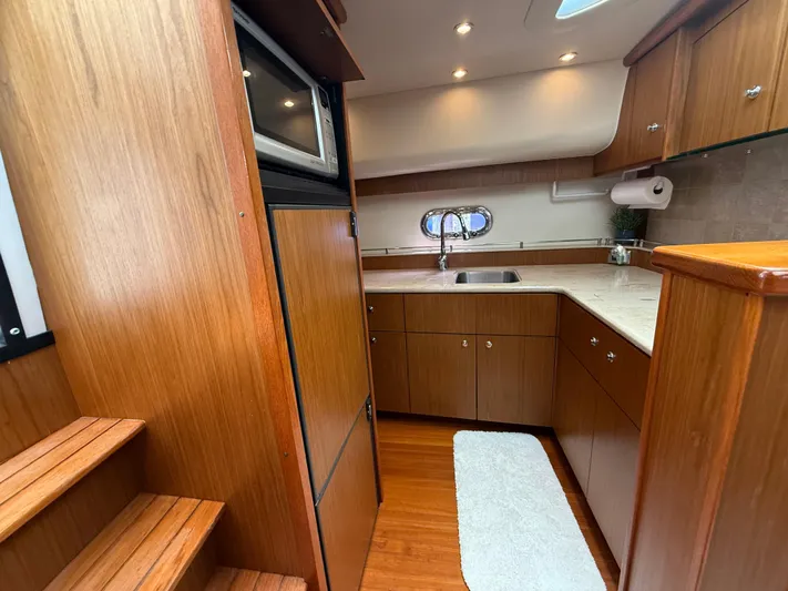  Yacht Photos Pics 2014 Tiara Yachts 4500 Sovran interior kitchen with wood cabinetry and modern appliances.