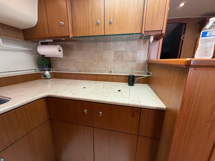  Yacht Photos Pics 2014 Tiara Yachts 4500 Sovran kitchen with wooden cabinets and marble countertop.