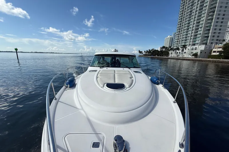  Yacht Photos Pics 2014 Tiara Yachts 4500 Sovran cruising near waterfront buildings under a clear blue sky.