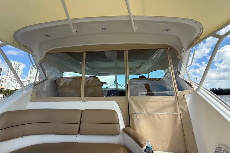  Yacht Photos Pics 2014 Tiara Yachts 4500 Sovran interior with beige seating and clear enclosure, city skyline view.