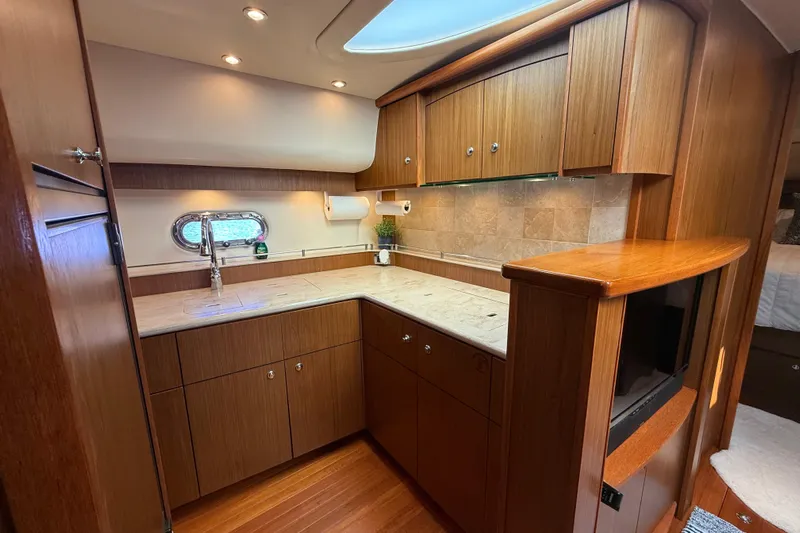  Yacht Photos Pics Luxurious 2014 Tiara Yachts 4500 Sovran kitchen with wood cabinetry and modern fixtures.