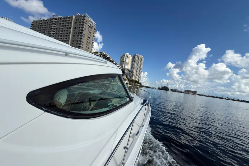  Yacht Photos Pics 2014 Tiara Yachts 4500 Sovran cruising near city skyline under blue sky.
