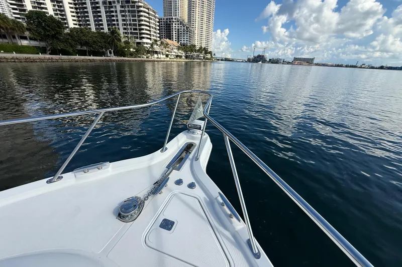  Yacht Photos Pics Bow view of 2014 Tiara Yachts 4500 Sovran, cruising near urban waterfront skyline.
