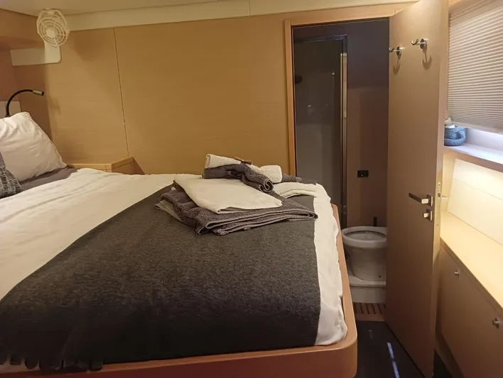 Finisterre Yacht Photos Pics Cozy cabin interior of 2017 Lagoon 52 F yacht with bed and ensuite bathroom.