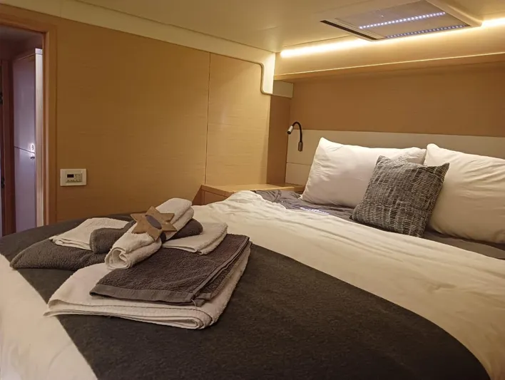 Finisterre Yacht Photos Pics Luxurious cabin interior of 2017 Lagoon 52 F yacht with neatly arranged bed and towels.