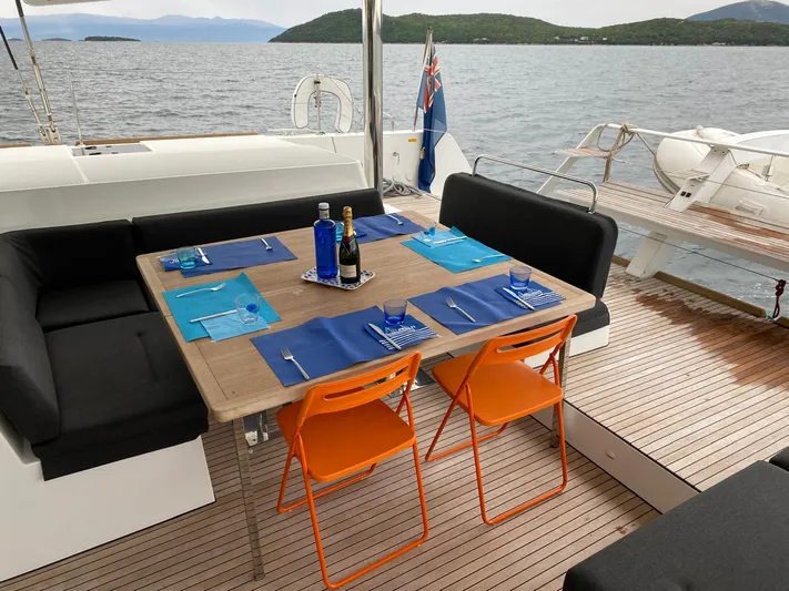 Finisterre Yacht Photos Pics Outdoor dining setup on 2017 Lagoon 52 F yacht, featuring a wooden table and ocean view.