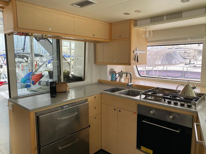 Finisterre Yacht Photos Pics Modern kitchen interior of 2017 Lagoon 52 F yacht with appliances and marina view.