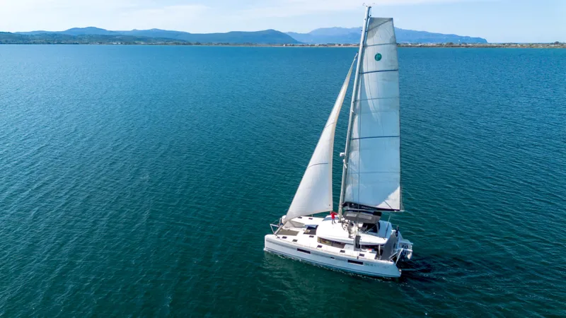 Finisterre Yacht Photos Pics 2017 Lagoon 52 F sailing on calm blue waters with distant mountains.