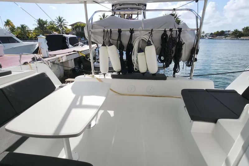  Yacht Photos Pics 2020 Lagoon 42 catamaran deck with seating, table, and ocean view.