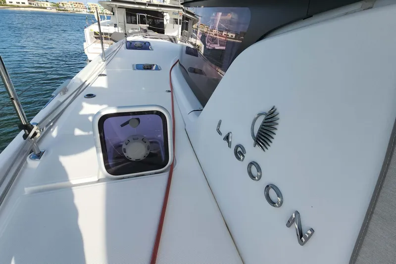 Yacht Photos Pics 2020 Lagoon 42 catamaran deck with logo, docked by the water.