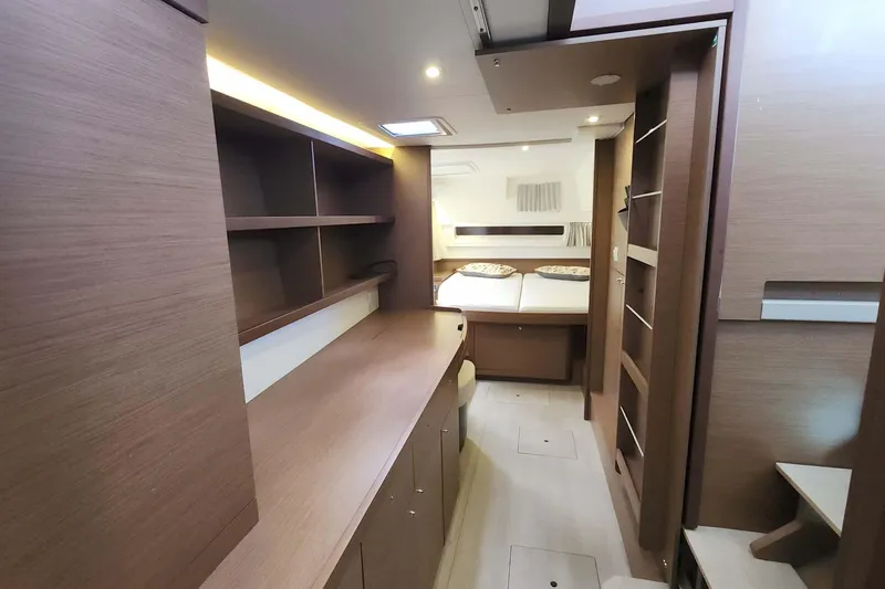  Yacht Photos Pics Luxurious interior of 2020 Lagoon 42 catamaran with modern wood finish and cozy bedroom.