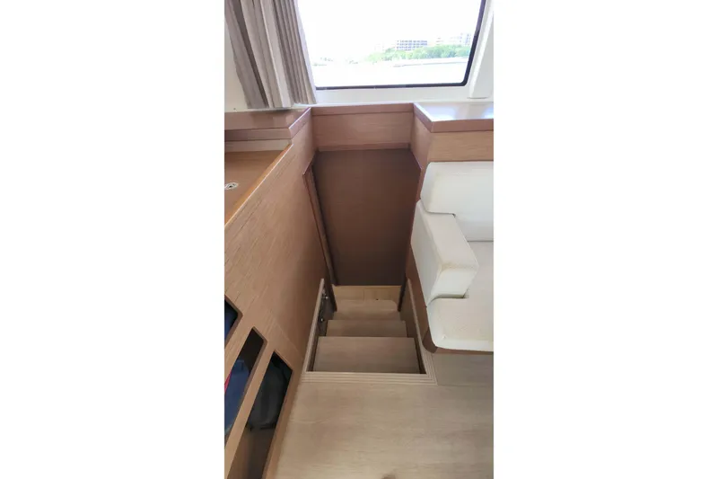  Yacht Photos Pics Interior stairs of 2020 Lagoon 42 catamaran with wooden finish and seating area.