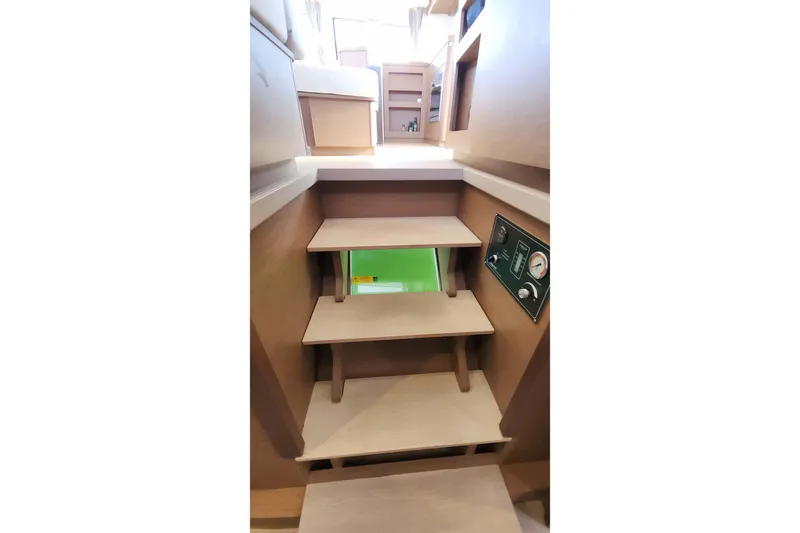  Yacht Photos Pics Interior stairs of 2020 Lagoon 42 catamaran, featuring wooden steps and control panel.