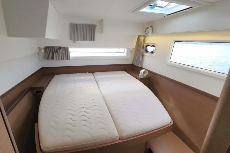  Yacht Photos Pics Luxurious cabin interior of 2020 Lagoon 42 catamaran with comfortable bedding and scenic windows.