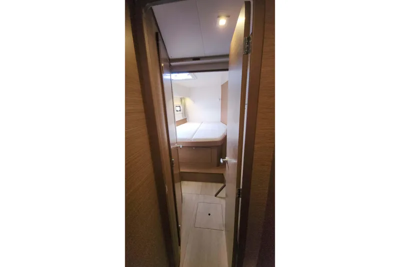  Yacht Photos Pics Interior view of 2020 Lagoon 42 yacht cabin with bed and wooden finish.