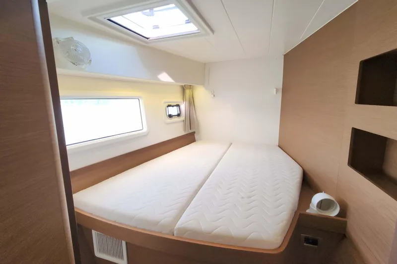  Yacht Photos Pics Interior cabin of 2020 Lagoon 42 catamaran with bed, window, and skylight.