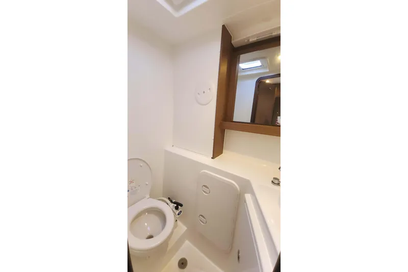  Yacht Photos Pics Bathroom interior of 2020 Lagoon 42 catamaran with toilet and mirror.