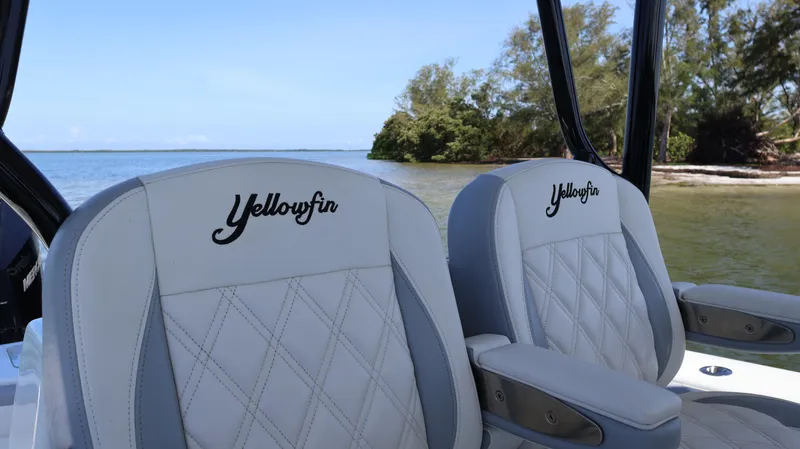  Yacht Photos Pics 2022 Yellowfin 32 Offshore boat seats with embroidered logo, near scenic shoreline.