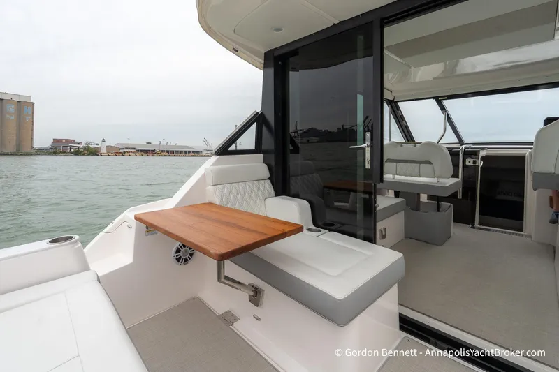 Qss Century Yacht Photos Pics 2024 Regal 36 XO yacht interior with seating and table, overlooking waterfront.