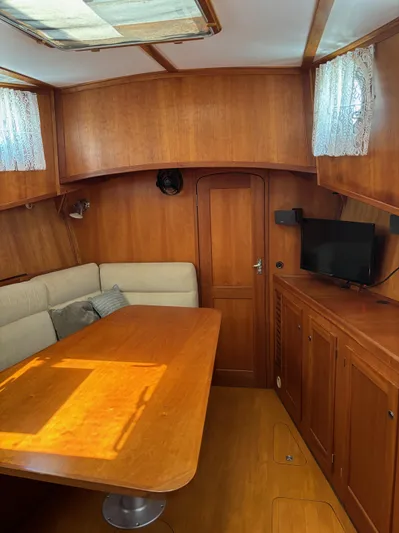 Diesel Duck Yacht Photos Pics 1999 Diesel Duck Trawler interior with wooden dining area and TV.