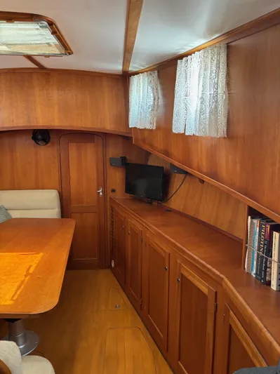 Diesel Duck Yacht Photos Pics 1999 Diesel Duck Trawler interior with wooden cabinetry, dining area, and small TV.
