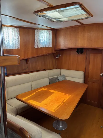 Diesel Duck Yacht Photos Pics Cozy interior of 1999 Diesel Duck Trawler with wooden table and cushioned seating.
