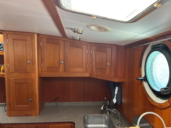 Diesel Duck Yacht Photos Pics Interior of 1999 Diesel Duck Trawler with wooden cabinets and porthole window.