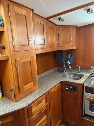 Diesel Duck Yacht Photos Pics 1999 Diesel Duck Trawler kitchen with wooden cabinets and compact sink area.
