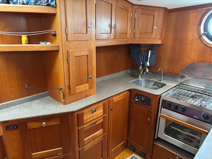 Diesel Duck Yacht Photos Pics 1999 Diesel Duck Trawler kitchen with wooden cabinets, stove, and sink.