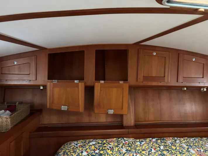 Diesel Duck Yacht Photos Pics Wooden interior of 1999 Diesel Duck Trawler with storage cabinets and floral bedding.