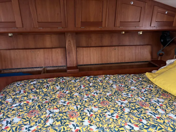Diesel Duck Yacht Photos Pics 1999 Diesel Duck Trawler interior with floral bedspread and wooden cabinetry.