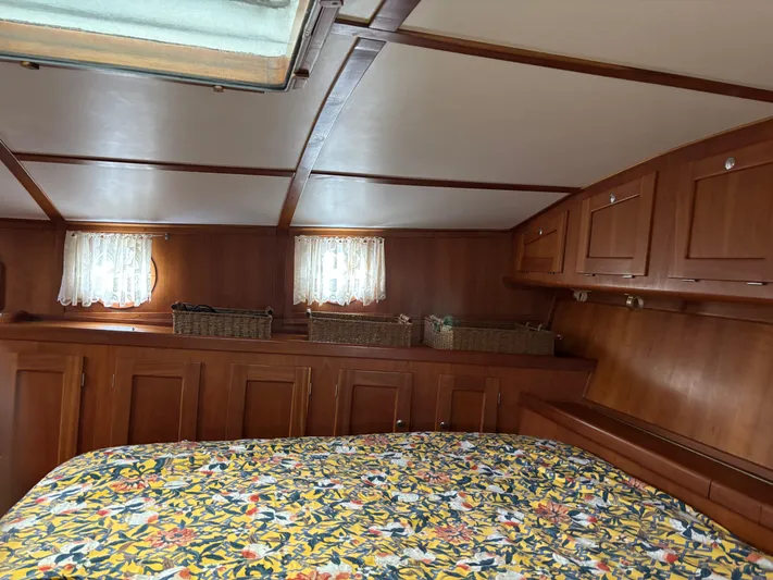 Diesel Duck Yacht Photos Pics Cozy cabin interior of 1999 Diesel Duck Trawler with floral bedding and wooden storage.