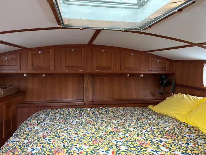 Diesel Duck Yacht Photos Pics Cozy cabin interior of 1999 Diesel Duck Trawler with floral bedding and wooden storage cabinets.