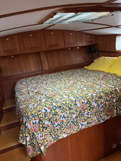 Diesel Duck Yacht Photos Pics Cozy cabin interior of 1999 Diesel Duck Trawler with floral bedding and wooden cabinetry.
