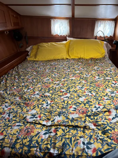 Diesel Duck Yacht Photos Pics Cozy cabin bedroom in 1999 Diesel Duck Trawler with floral bedding and yellow pillows.
