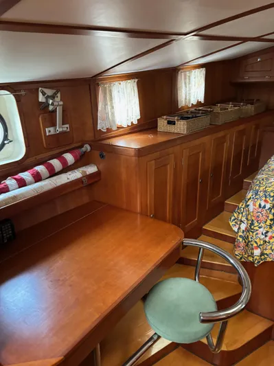 Diesel Duck Yacht Photos Pics 1999 Diesel Duck Trawler interior with wooden cabinetry, desk, and chair. Cozy nautical design.
