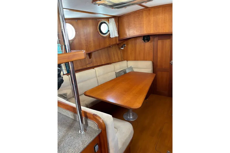 Diesel Duck Yacht Photos Pics Cozy interior of 1999 Diesel Duck Trawler with wooden table and cushioned seating.