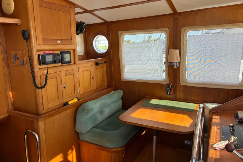 Diesel Duck Yacht Photos Pics 1999 Diesel Duck Trawler interior with wooden cabinetry, seating, and navigation equipment.