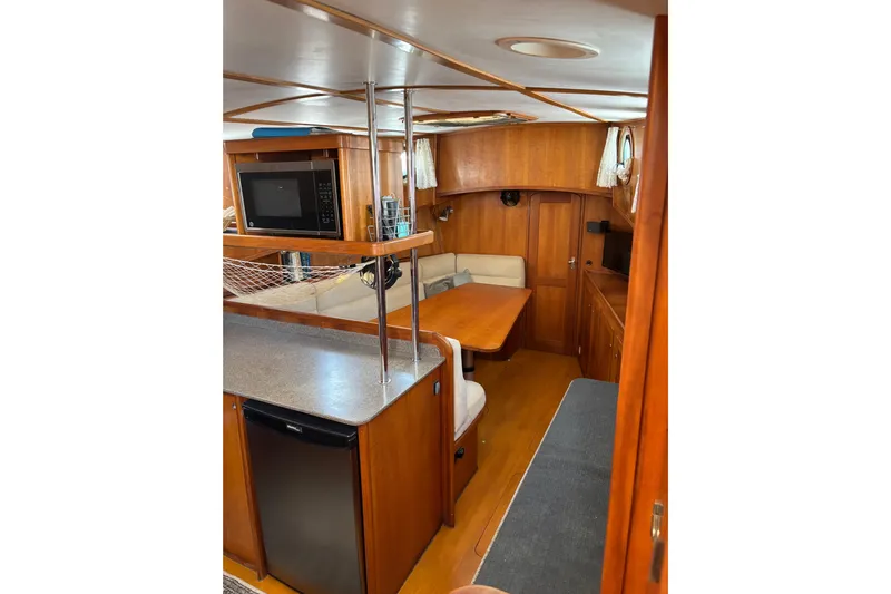 Diesel Duck Yacht Photos Pics Interior of 1999 Diesel Duck Trawler with kitchen and dining area, featuring wood finish.