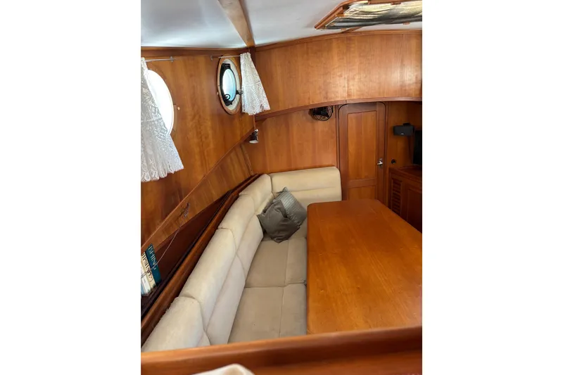 Diesel Duck Yacht Photos Pics Cozy interior of 1999 Diesel Duck Trawler with wooden table and cushioned seating.
