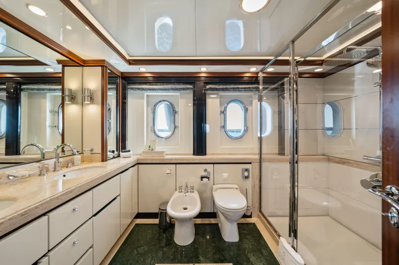 Titian Pearl Yacht Photos Pics Luxurious yacht bathroom with dual sinks, shower, and porthole windows on CRN Magnifica 43.