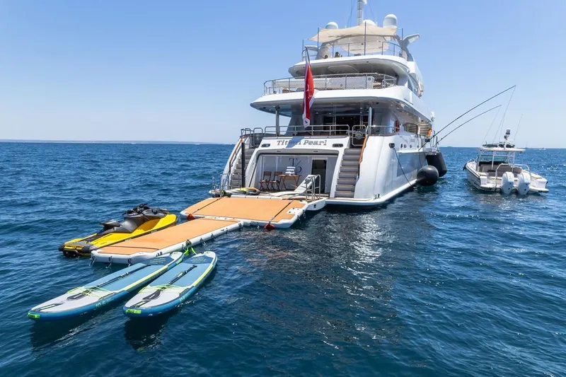 Titian Pearl Yacht Photos Pics Luxury yacht CRN Magnifica 43, 2001 model, with paddleboards and jet ski on the ocean.