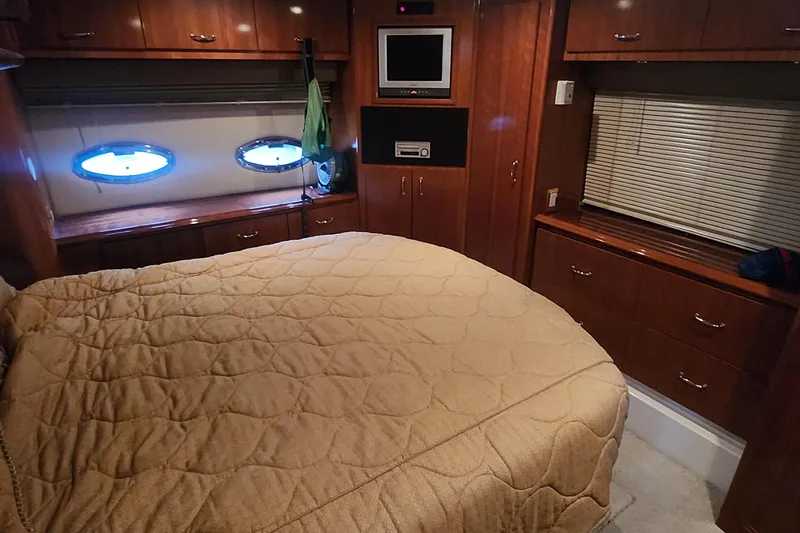  Yacht Photos Pics Luxurious 2005 Carver 466 Motor Yacht bedroom with wood cabinetry and cozy bedding.