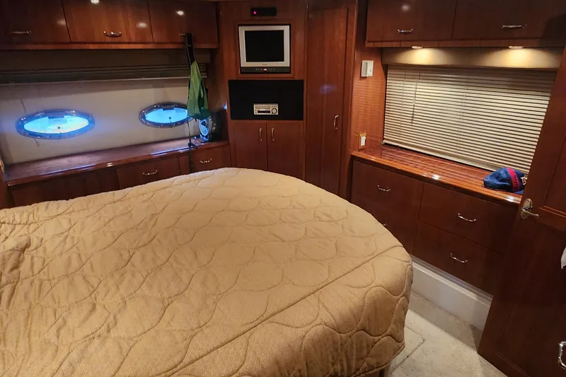  Yacht Photos Pics Luxurious 2005 Carver 466 Motor Yacht bedroom with wood cabinetry and cozy bedding.